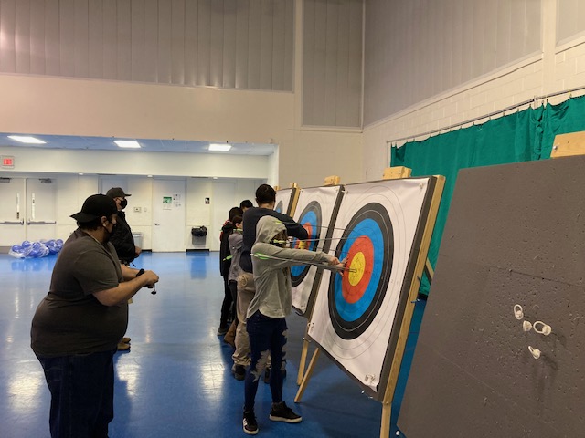 Youth athletes trying archery pulling arrows out of a target at Foss Park District in North Chicago with All Kids Play youth sports financial assistance grant