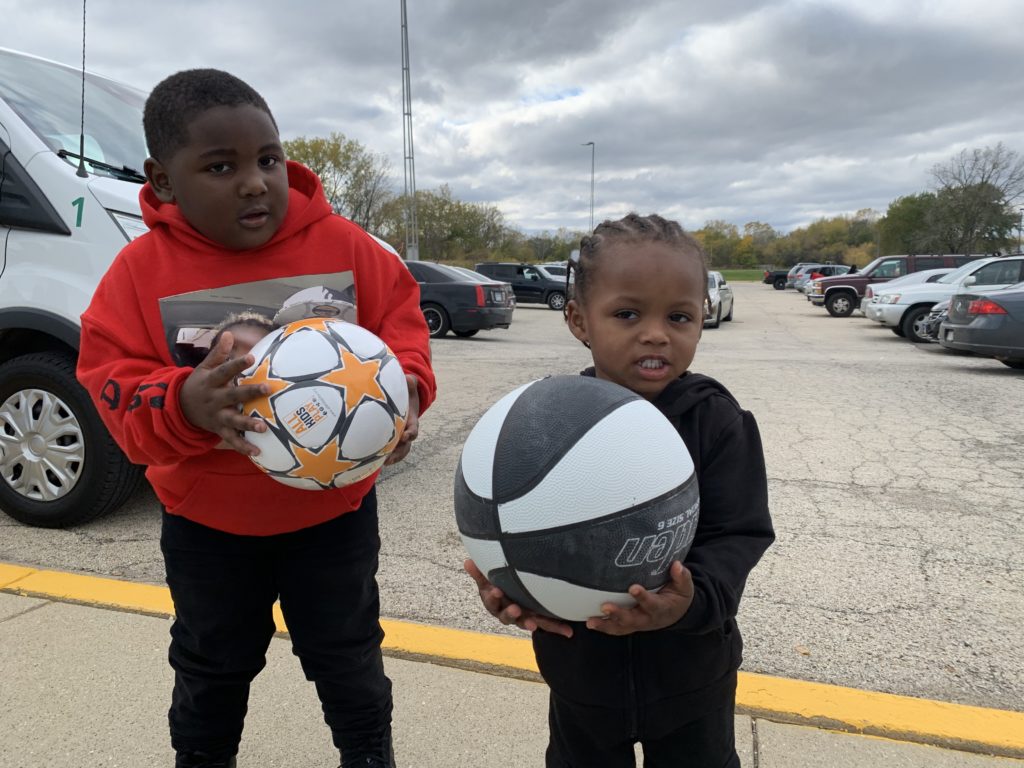 Two youth athlete boys with a basketball and soccer ball at Foss Park District in North Chicago at All Kids Play Bounce Back sports ball giveaway