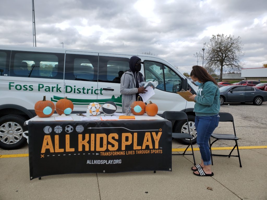 Mom registering child for soccer and basketball giveaway at Foss Park District in North Chicago at All Kids Play Bounce Back sports ball giveaway